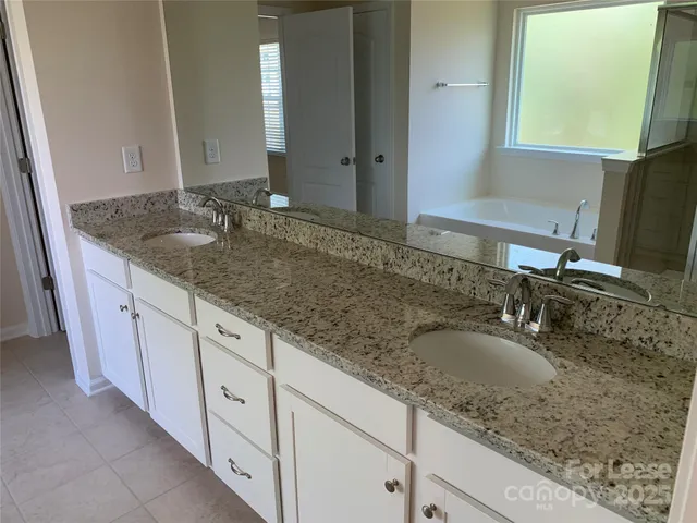 a bathroom with sink granite and a mirror