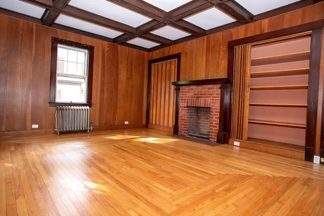 a view of an empty room with a fireplace and a window