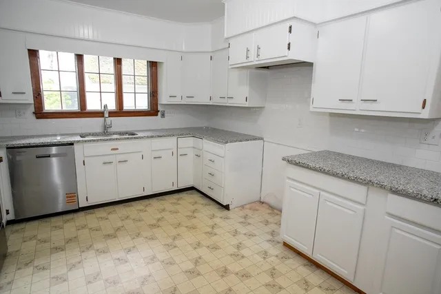 a kitchen with granite countertop white cabinets white stainless steel appliances and sink