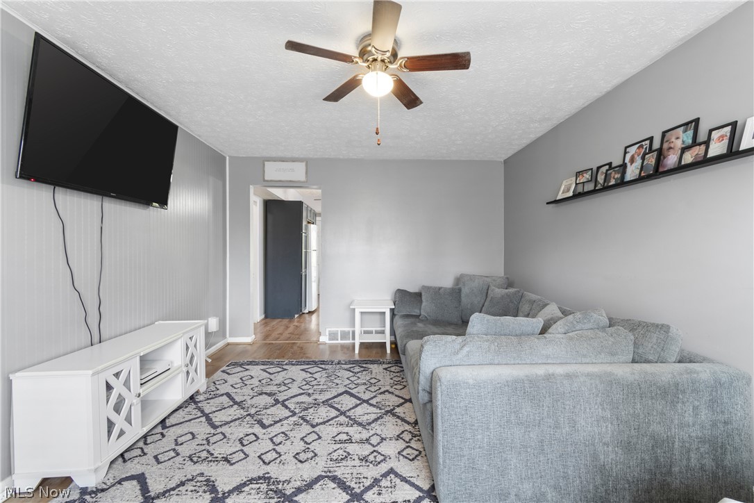 1934 Springfield Center Road Akron, OH 44312 - Photo 5 of 30 Living room with wood-type flooring, ceiling fan, and a textured ceiling