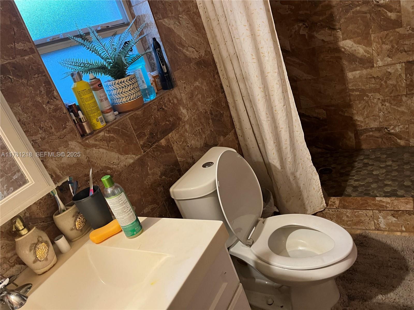 6546 Southwest 20th Court Miramar, FL 33023 - Photo 2 of 19 a bathroom with a toilet sink and mirror