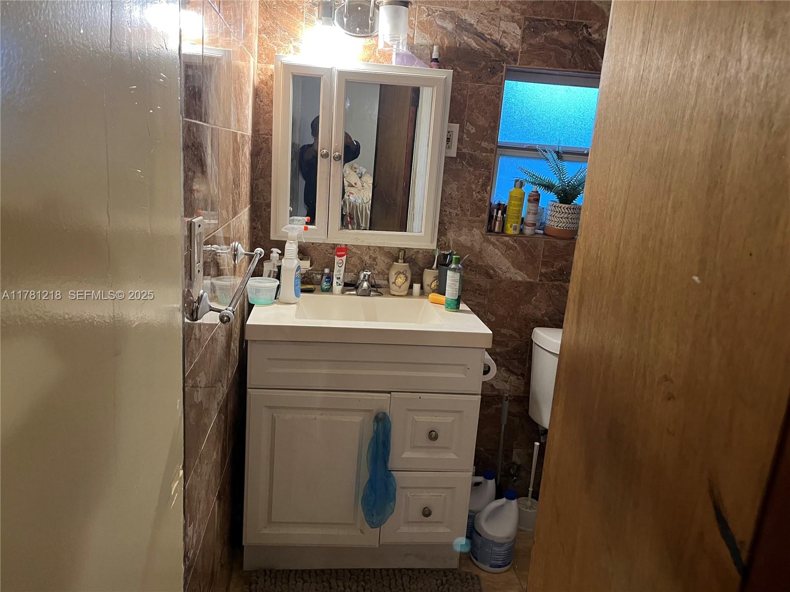 6546 Southwest 20th Court Miramar, FL 33023 - Photo 3 of 19 a bathroom with a sink and a mirror