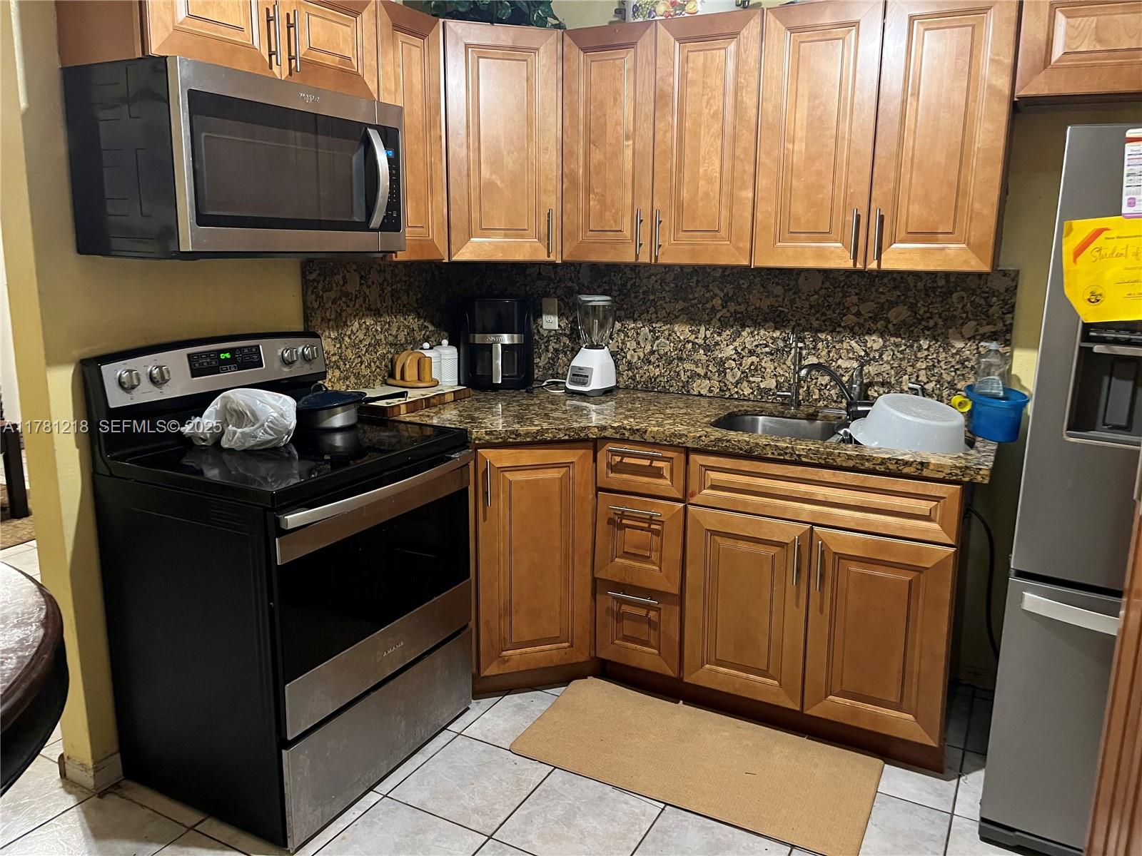 6546 Southwest 20th Court Miramar, FL 33023 - Photo 7 of 19 a kitchen with stainless steel appliances granite countertop a stove a sink and a microwave