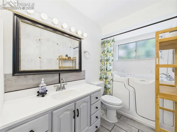 a bathroom with a toilet a sink and mirror