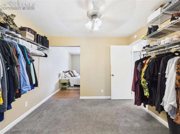 a view of walk in closet with clothes and shoes