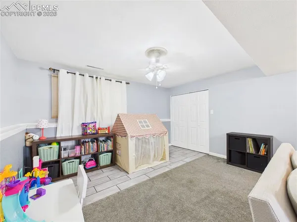 a living room with furniture and a baby crib
