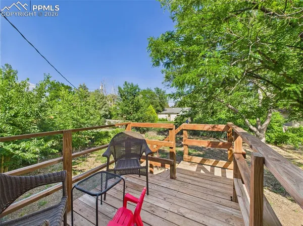 a view of deck with furniture and trees