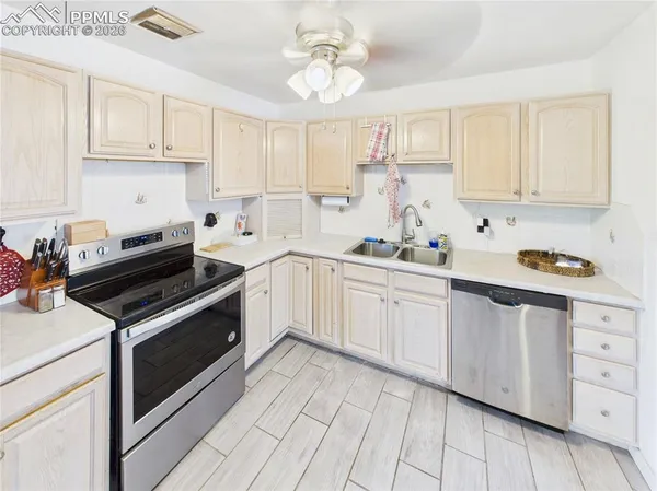 a kitchen with cabinets appliances a sink and a window