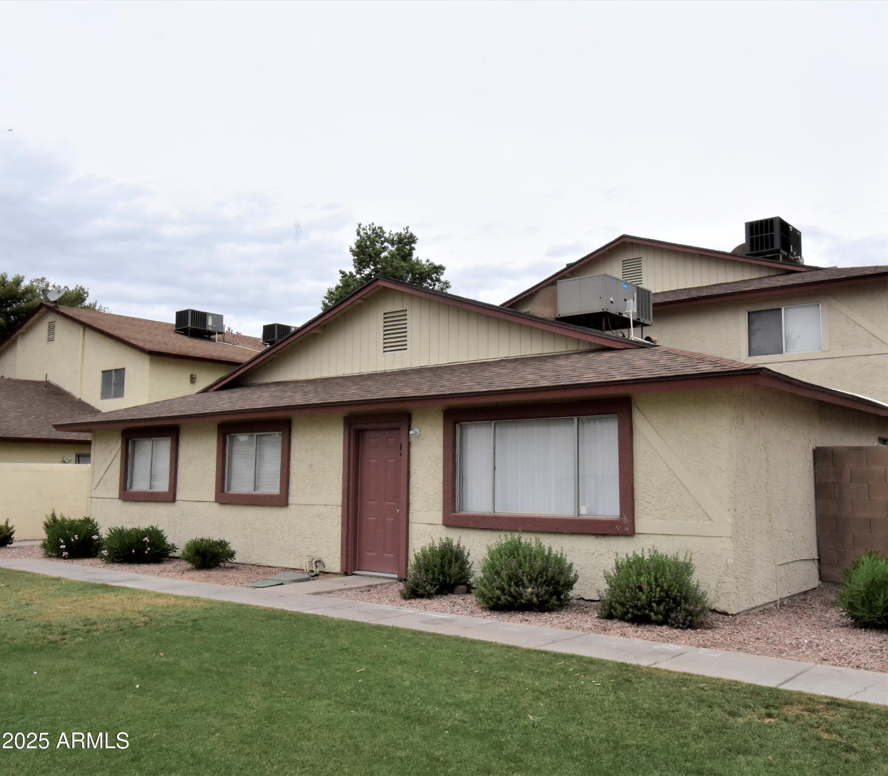 860 East Brown Road, Unit 66 Mesa, AZ 85203 - Photo 1 of 30 a front view of a house with a yard and potted plants