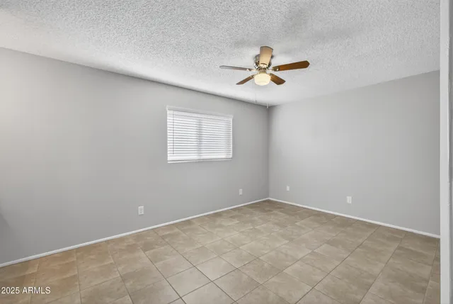 an empty room with closet and a chandelier fan