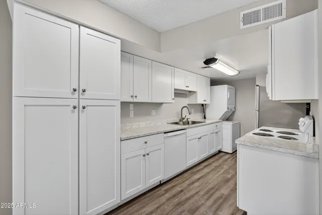 a kitchen with white cabinets and white appliances