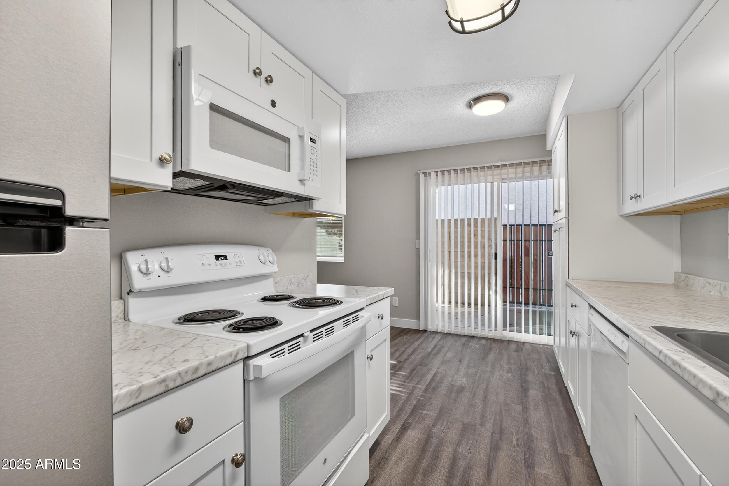 860 East Brown Road, Unit 66 Mesa, AZ 85203 - Photo 10 of 30 a kitchen with granite countertop white cabinets and white appliances