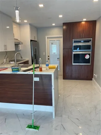 a kitchen with stainless steel appliances kitchen island granite countertop a sink and cabinets