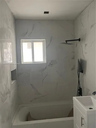a bathroom with a tub and a window