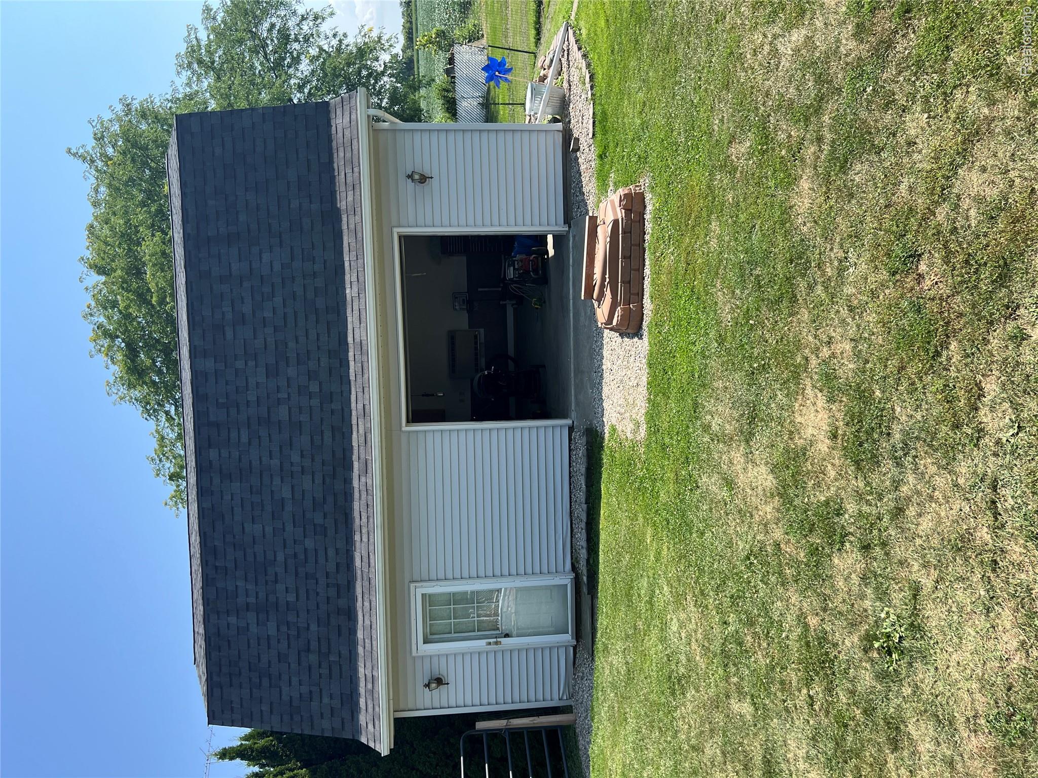 5417 North Road North Street, MI 48049 - Photo 23 of 30 Detached outbuilding with light-colored siding, a dark shingled gambrel roof, and an open garage bay