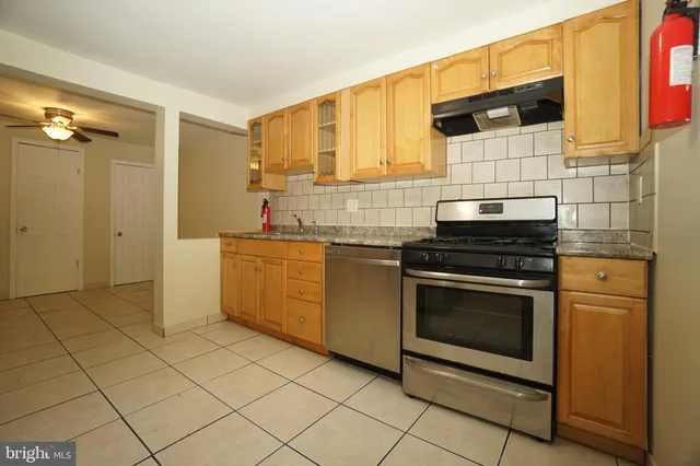 a kitchen with stainless steel appliances a stove a sink and a microwave