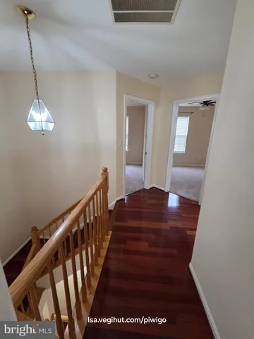 a view of entryway and hall with wooden floor