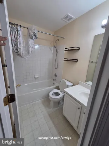a bathroom with a granite countertop sink a toilet a mirror and shower