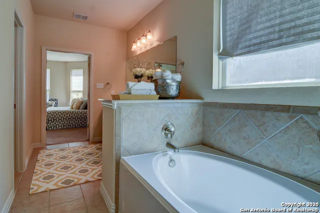 a bathroom with a tub sink and mirror