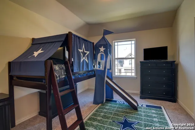 a bedroom with a bed and a flat tv screen on dresser