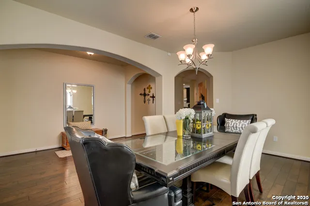 a dining room with furniture a chandelier and wooden floor
