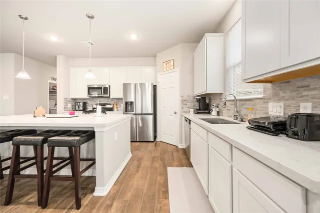 a kitchen with kitchen island granite countertop wooden cabinets and white appliances