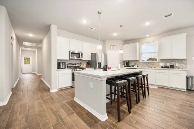 a kitchen with a sink a counter top space stainless steel appliances and cabinets