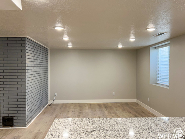 702 North 100 West Logan, UT 84321 - Photo 18 of 58 Basement with baseboards, visible vents, wood finished floors, and a textured ceiling