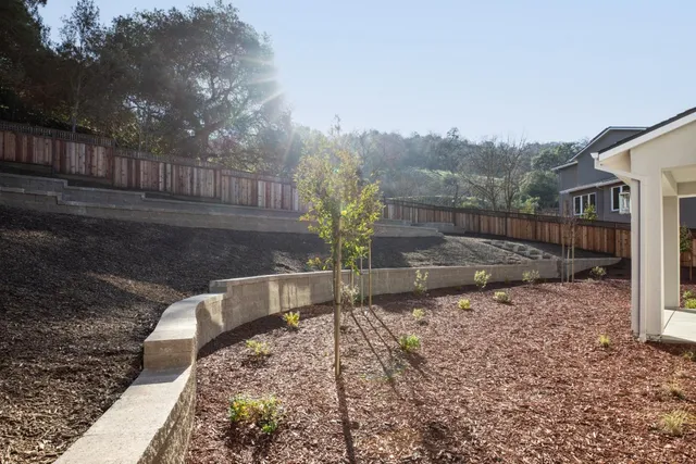 a view of a yard with wooden fence
