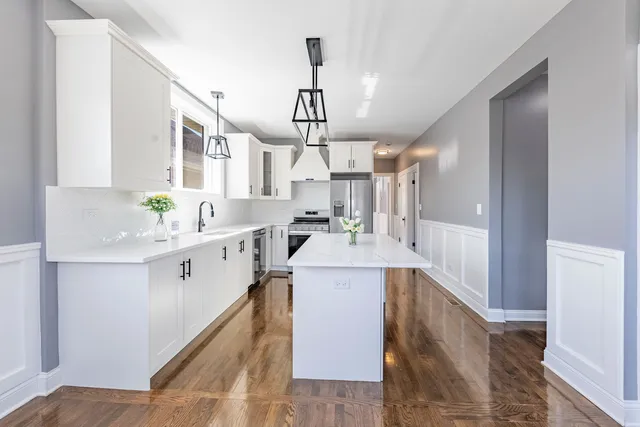 a kitchen with a sink cabinets stainless steel appliances and a window