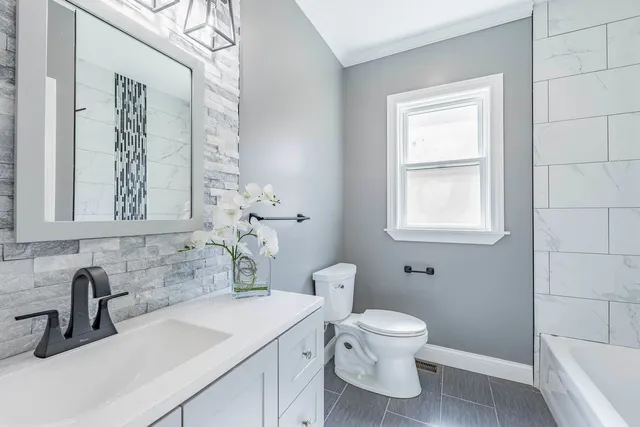 a white toilet and tub sitting next to a window
