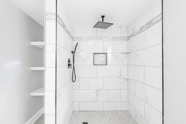 an empty room with a bench and a window