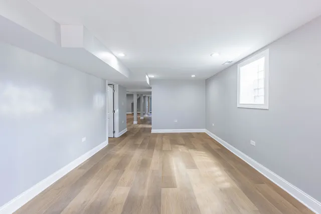 a view of a hallway with a white wall and a window