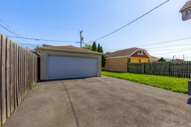 a view of a house with a small yard and wooden fence