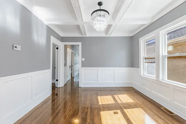 a view of empty room with wooden floor and window