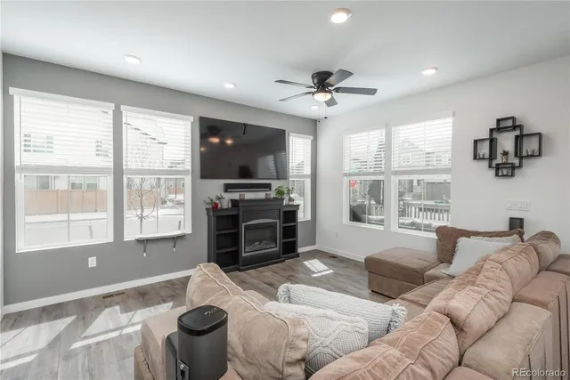 a living room with furniture a flat screen tv and a large window