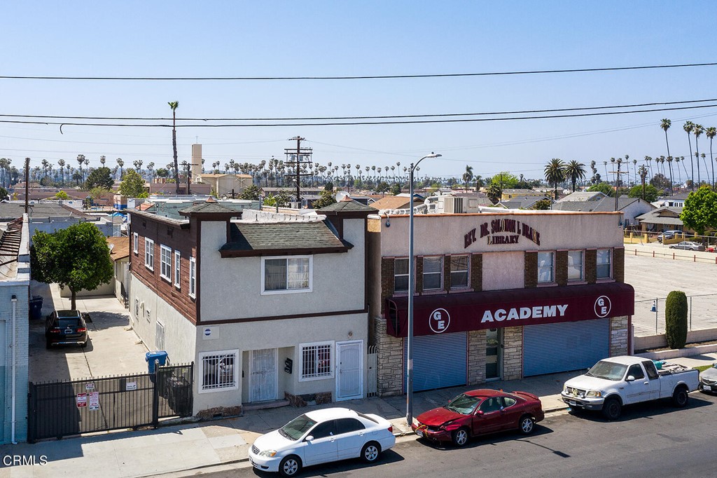 a front view of a building with cars parked