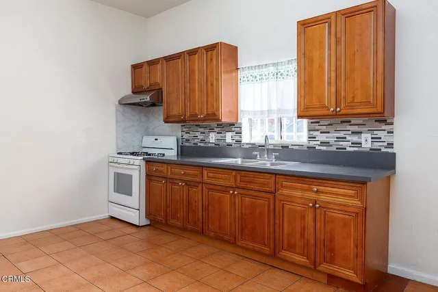 a kitchen with stainless steel appliances granite countertop a sink and a window