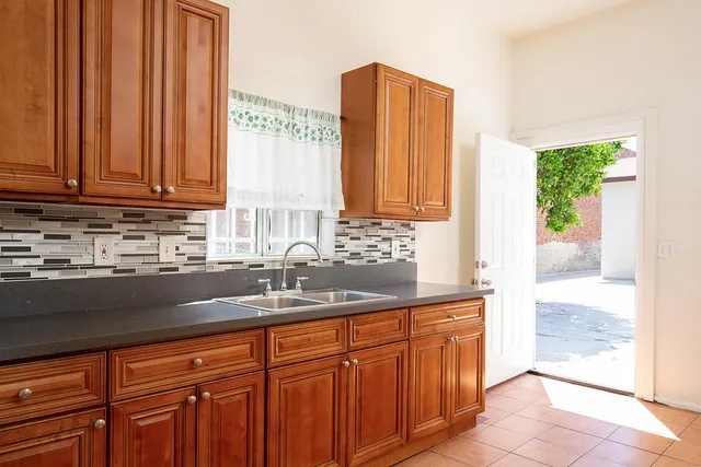 a kitchen with stainless steel appliances granite countertop a sink a refrigerator and a wooden cabinets