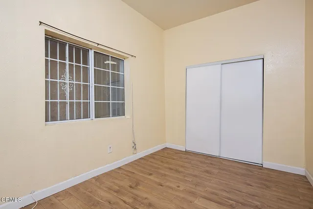 a view of empty room with wooden floor and windows