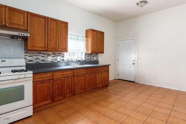 a kitchen with stainless steel appliances granite countertop a stove a sink and a refrigerator