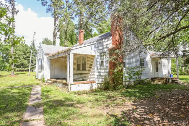 a view of a house with backyard and a tree