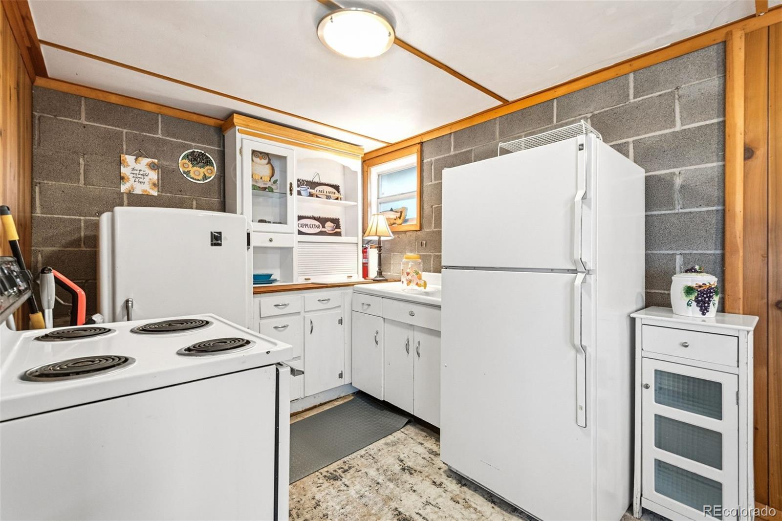25845 Wilkerson Road Conifer, CO 80433 - Photo 8 of 16 a kitchen with white cabinets and white appliances
