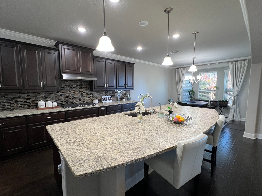 4121 Cappello Way Leander, TX 78641 - Photo 11 of 40 a kitchen with kitchen island a sink table and chairs
