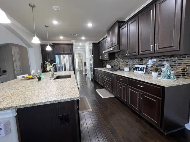 a large kitchen with stainless steel appliances and wooden cabinets