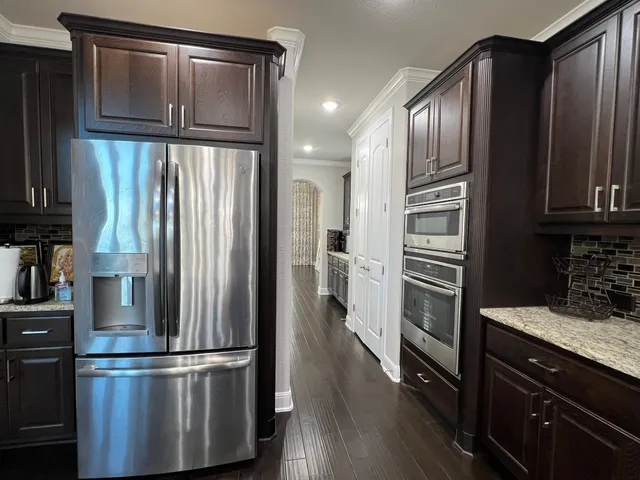 a large kitchen with stainless steel appliances lots of counter space and a sink