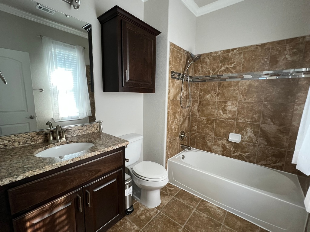 4121 Cappello Way Leander, TX 78641 - Photo 25 of 40 a bathroom with a granite countertop sink toilet and shower