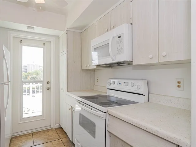 a kitchen with white cabinets and white appliances