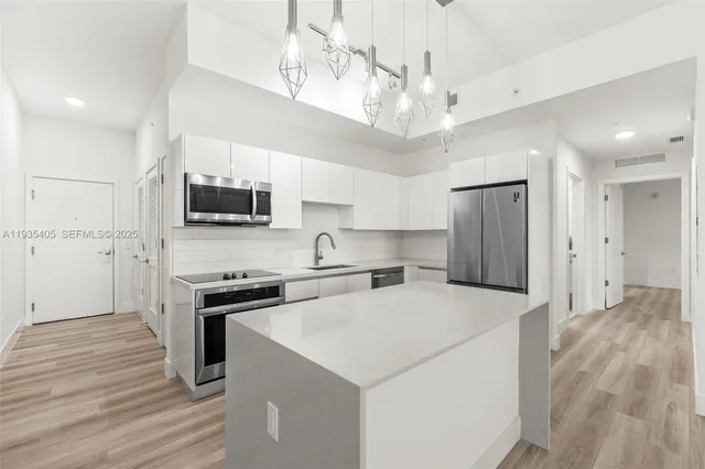 a kitchen with stainless steel appliances a sink stove and refrigerator