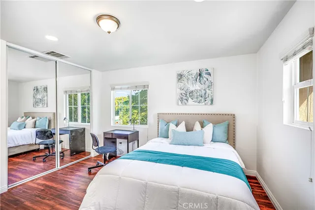 a bedroom with a bed and wooden floor